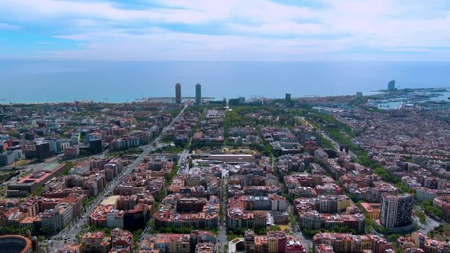 Cinematic 4K drone shot over Barcelona&rsquo;s iconic Eixample grid toward the twin Mapfre and Arts Hotel towers at Port Olimpic with sparkling Mediterranean coastline.