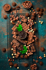 Chocolate background. Banner of chocolate, cocoa, nuts and cocoa beans. Top view, space for text.