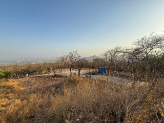 A barren field with a blue building in the middle