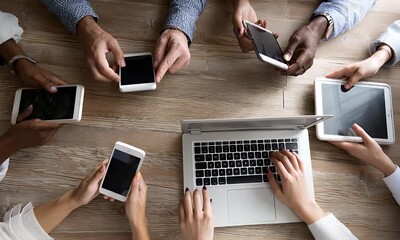 Diverse team using multiple digital devices at meeting. - Powered by Adobe