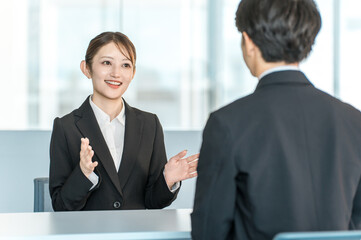Fototapeta premium 男性客と商談・接客・打ち合わせする若いアジア人ビジネスウーマン 