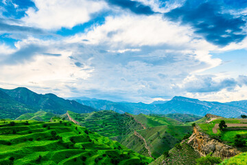 Obraz premium Incredibly beautiful landscape with clouds and green terraced mountains. North Caucasus