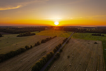 farm field on a summer evening with a beautiful sunset in the background
