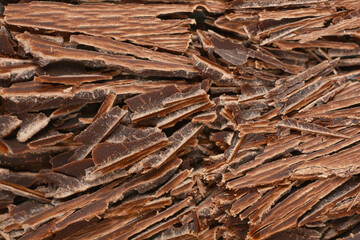 A textured close-up features a generous pile of irregular dark chocolate shavings, perfect for...