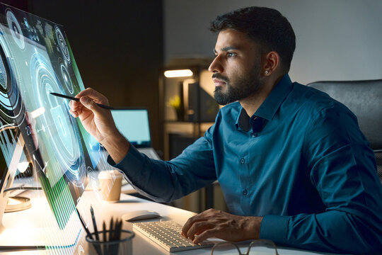 Professional working on a futuristic digital interface in a modern, dimly-lit office, focused on interactive visual data and technology advancement. Concept of innovation, digital transformation