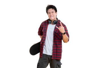A young man with a skateboard posing with rock and roll hand gesture and headphones on png background