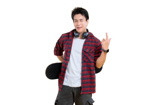 Young man in a plaid shirt holding a skateboard, with headphones around his neck on png background