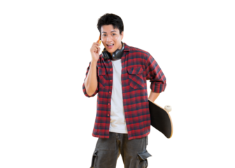 A young man holding a smartphone and skateboard with a cheerful expression. He wears a plaid shirt and cargo pants, his headphones around his neck on png background
