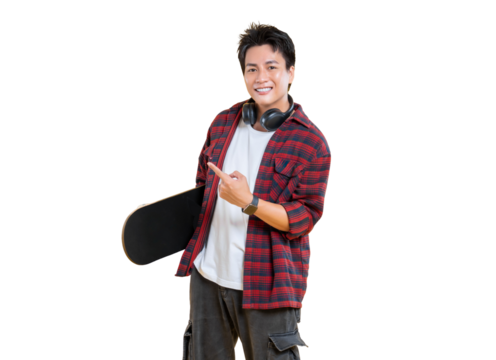A young man pointing with a skateboard in hand and headphones around his neck, smiling broadly and appearing cheerful on png background