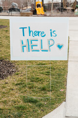 Community support sign displayed in a park conveys an important message about assistance during a...