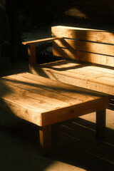A wooden table and chair lighted up by sun rays