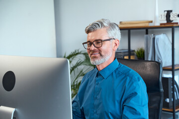 Professional Man Working In Modern Office Environment, Focused And Engaged On His Computer With A...