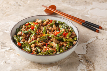 Pork mince fried with green beans, bell pepper, garlic, ginger and soy sauce close-up in a bowl on...