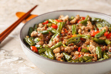 Crispy Pork Stir Fry with Green Beans, garlic and bell pepper closeup in the bowl on the table. Horizontal