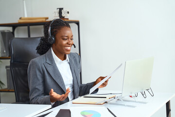 Woman in a Business Suit Conducting an Online Meeting or Presentation With a Headset, Expressing...