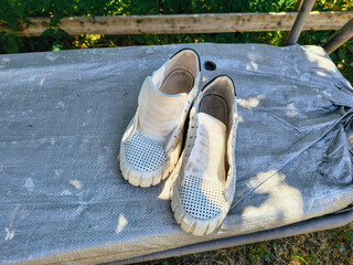 white sneakers. white shoes. Sneakers drying on window sill against green backdrop. Urban lifestyle...