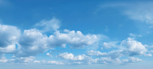 Fototapeta premium The expansive blue sky filled with fluffy clouds on a bright day.