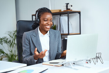 Professional Woman Wearing Headphones Conducting Virtual Meeting On Laptop, Discussing Business...