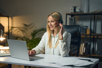 Smiling Woman With Headset Engaged In Video Call From Home Office, Professional Workspace...