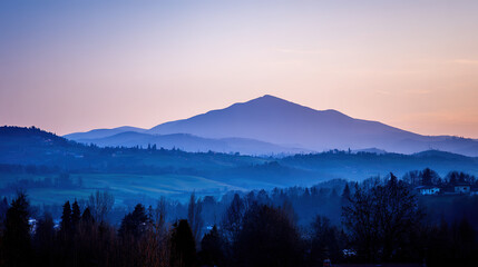 Obraz premium Mountain landscape bathed in twilight hues of deep blue and fading sunset colors.