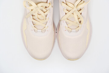 Casual sneakers with light color and modern design placed on clean surface, ideal for everyday wear and activities