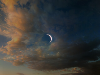 New moon in the evening sky. Astronomical landscape with the moon between the clouds.