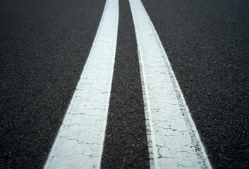 Obraz premium Asphalt road with double white lines, close up