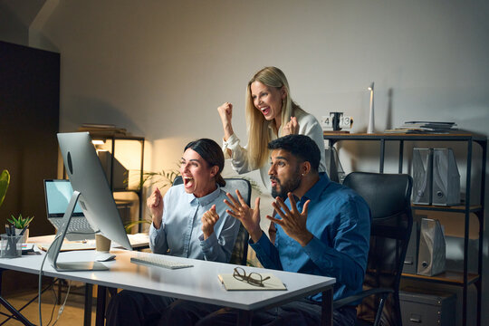 Professional team celebrating success in a modern office with passion and excitement, illustrating teamwork, achievement, and motivation in a collaborative business environment