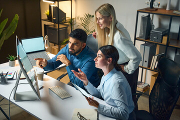 Fototapeta premium Team Collaborating On Technology Projects In Modern Office Environment, Engaging In Active Problem-Solving And Brainstorming While Using Computers.