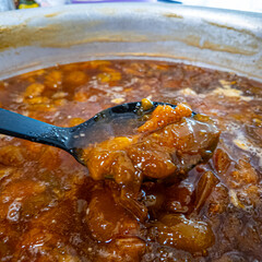 jam in a large saucepan. plum jam. apricot jam. Boiling apricot jam in a saucepan, view from above. Fragrant orange berries and foam in a saucepan on the stove.