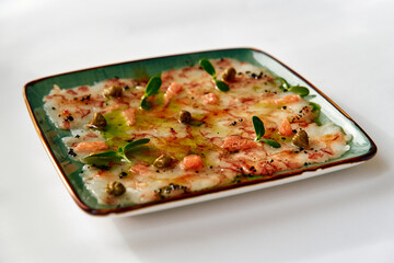 Delicate Carpaccio Dish with Lightly Seasoned Seafood, Fresh Herbs, and a Drizzle of Olive Oil Perfectly Arranged on a Rustic Plate