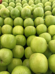 a bunch of green apples stacked together