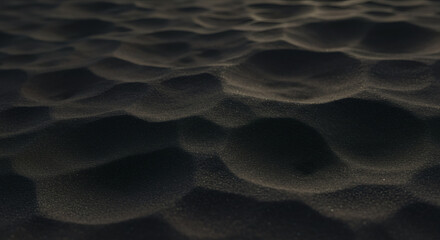 Close-up view of dark sand texture.