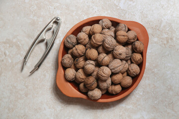 Whole and cracked walnuts and nutcracker