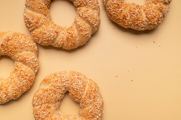 Simit or gevrek, round bagel with sesame seeds on beige background top view. Creative layout with food. Traditional Turkish pastry. Delicious fresh homemade pastry, bakery product. Bagel mockup