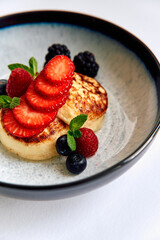 Delicious Pancakes Served with Fresh Berries and Mint Leaves in a Stylish Bowl for a Perfect Breakfast Experience