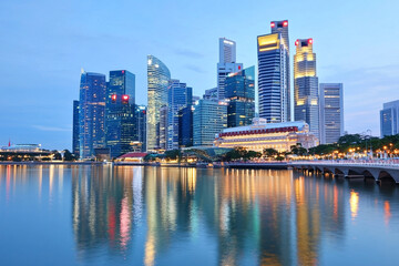 Fototapeta premium City skyline illuminated at dusk with tranquil water reflections