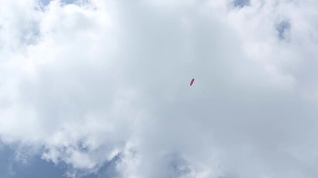 The beauty of paragliding in free flight. Beautiful blue sky on a sunny summer day. View of the paraglider against the blue sky and sun. Cerna Hora in Janskie Lazne.