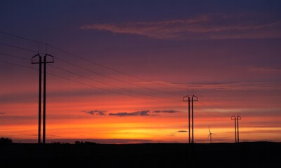 Silhouetted power lines against a vibrant sunset (1)