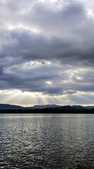 Obraz premium Dramatic Sky and Lake with Mountain Silhouette