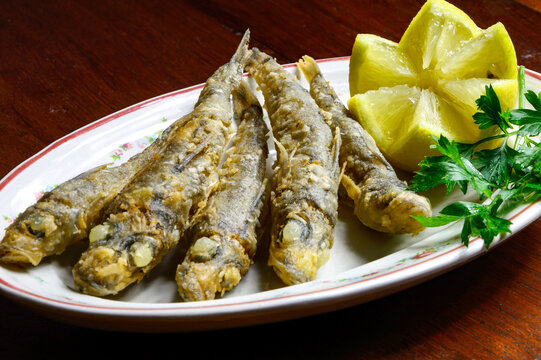 Pescadito frito con una hoja de perejil y lim&oacute;n, pescadilla frita 