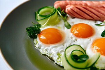 A Delicious Breakfast Plate Featuring Sunny-Side Up Eggs with Fresh Cucumber, Celery, and Sausage, Perfect for a Balanced Meal to Start Your Day Right