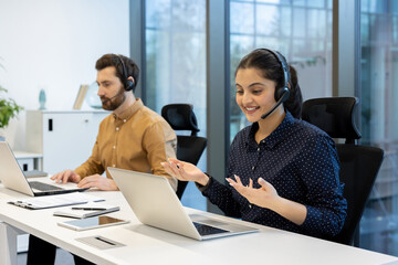 A diverse team of call center agents working on their laptops, engaged in customer service, showcasing professional communication.