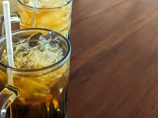 Iced tea served in jumbo glasses on a wooden table. A favorite refreshing drink of most Indonesians, it is a refreshing drink during summer in tropical climates.
