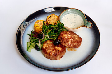 A Delicious Entree Featuring Savory Meat Patties Served with Grilled Vegetables, Fresh Salad, and a Creamy Dipping Sauce Creating a Gourmet Experience
