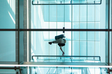 Bottom view through a transparent glass floor of a woman in a modern business center. Modern architecture and business