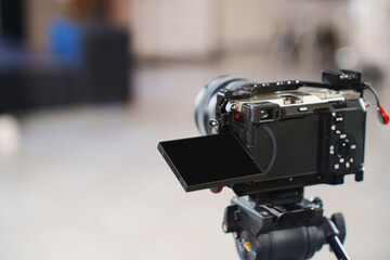 Camera positioned on tripod ready for filming indoors in modern studio