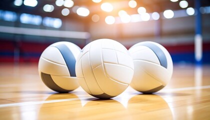 Three volleyballs on a polished indoor court, reflecting the bright lights, ready for a game.