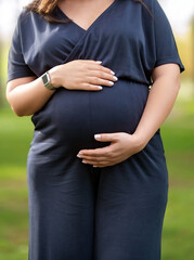 Young pregnant woman stands outdoor