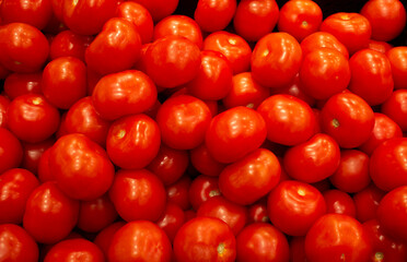 Close-up of lying fresh red tomatoes in supermarket boxes.